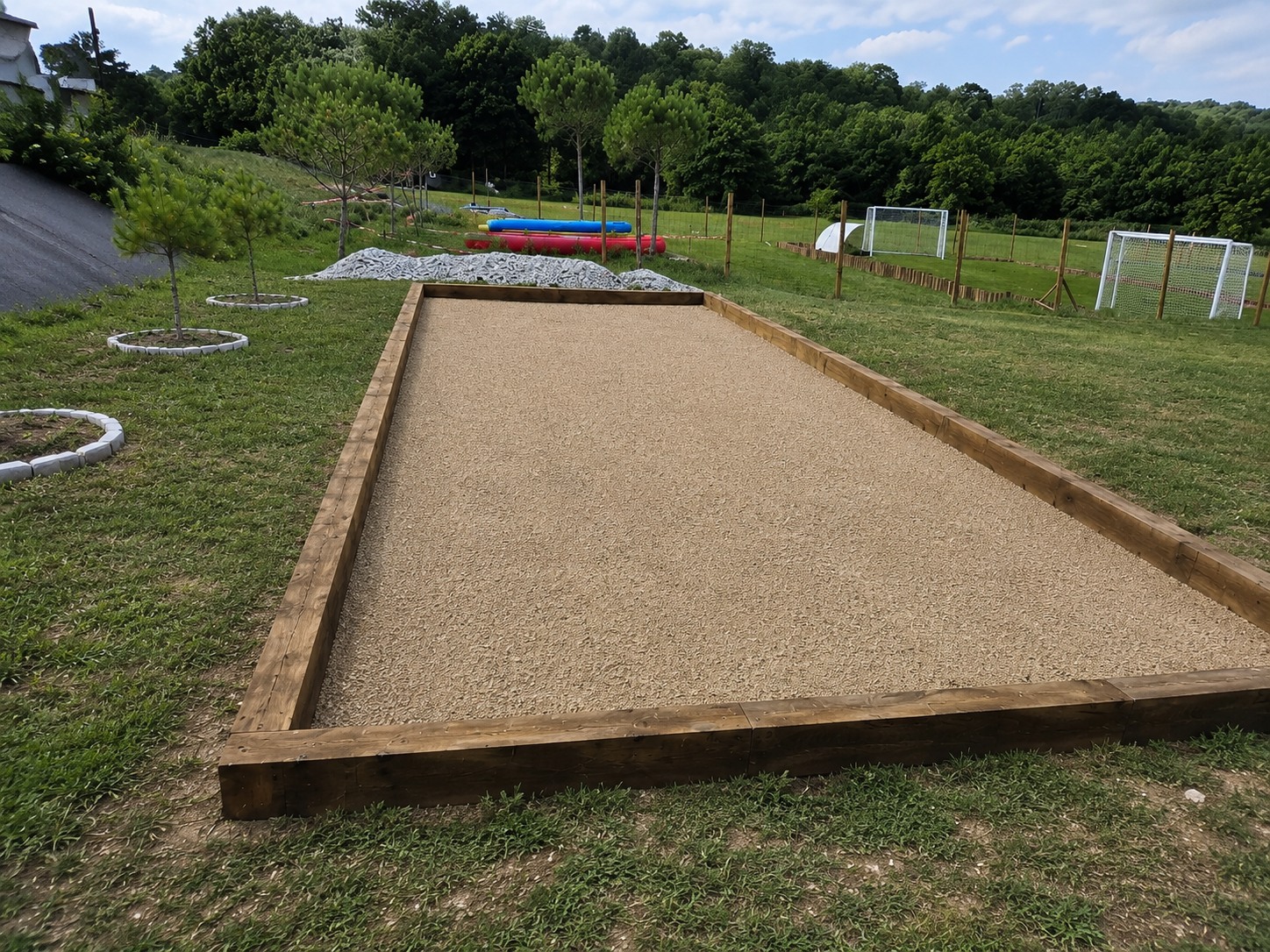 Terrain de pétanque terminé avec bordures bois et finition stabilisée