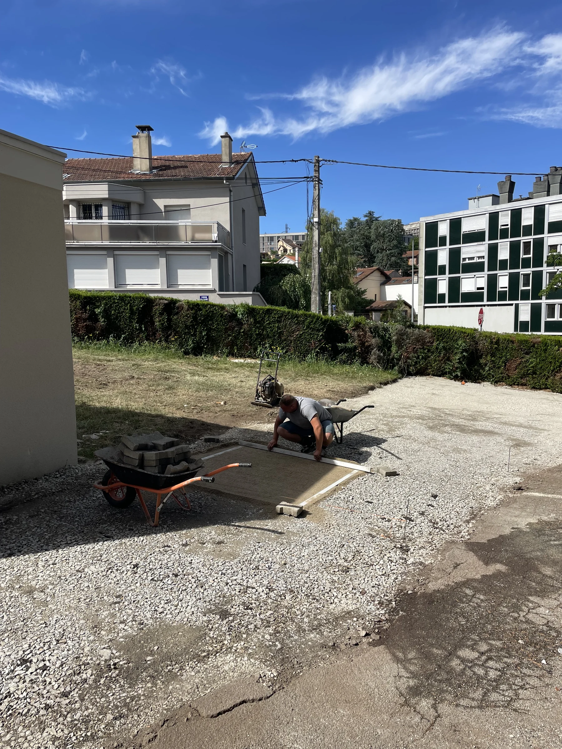 Préparation d'une allée pavée devant une maison